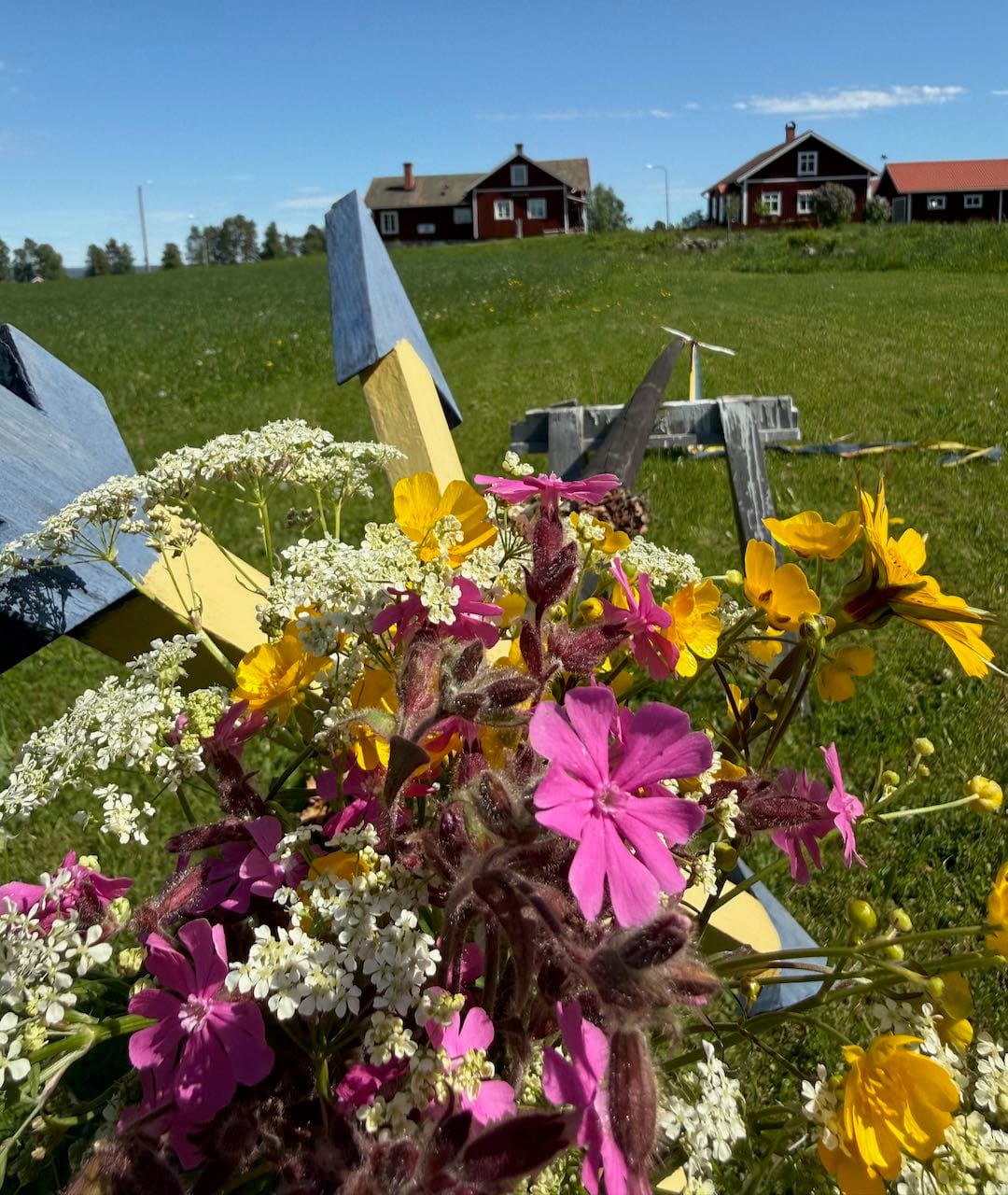 Blommor framför midsommarstång
